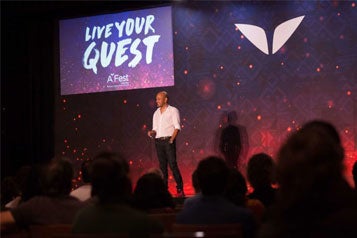 a person standing on a stage with a crowd watching