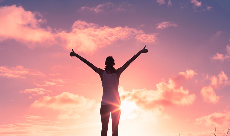 a person standing in front of a sunset