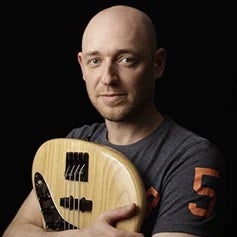 a bald man holding a yellow and white football ball