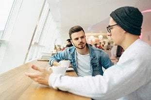 Being an Exponential Coach a man and a woman sitting at a table with a cup of coffee