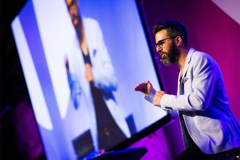 Mindvalley-U-2018-004A7768-Photo-by-Kersti-Niglas-min-1-1-1-scaled-min a man speaking on a microphone