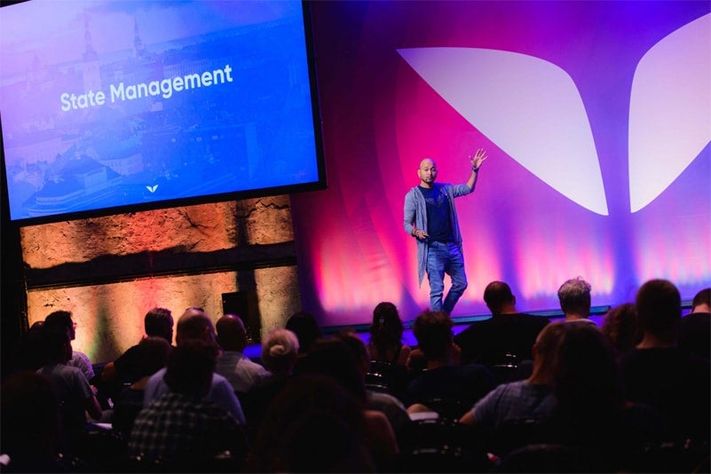 a person standing on a stage with a crowd watching