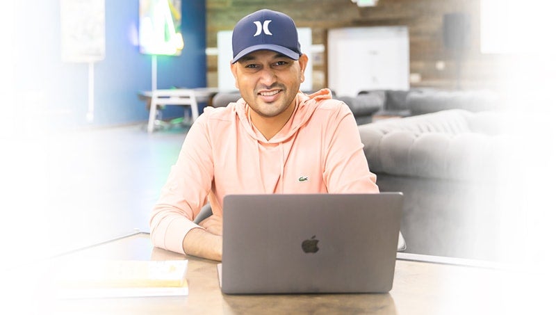 bonus-1-responsive-min a person sitting at a table with a laptop