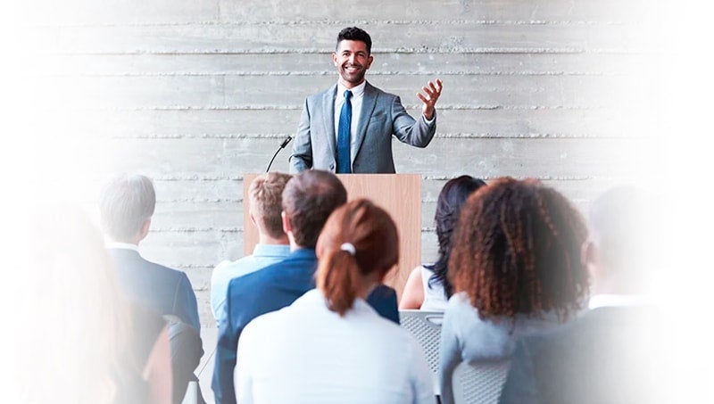 bonus-16-responsive-min a person standing in front of a group of people