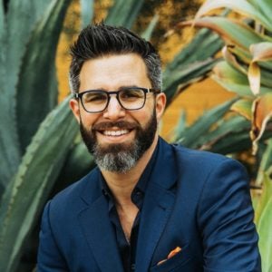 a man with glasses smiling