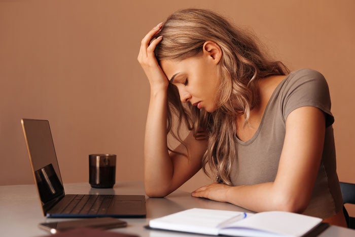 Evercoach a woman sitting at a desk with a laptop and a pen